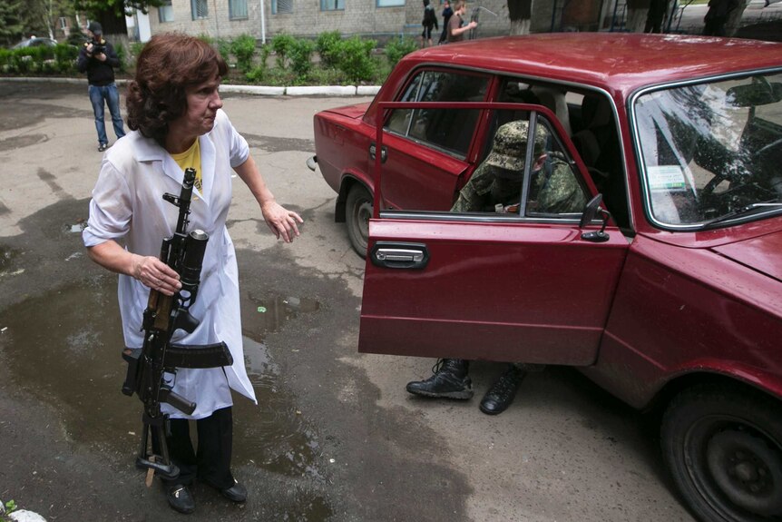 An injured pro-Russian is helped out of a car by a medical staff at a hospital at the town of Slaviansk.