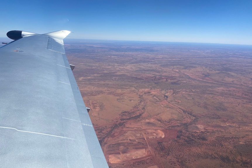 The wing of an aircraft flying above the Western Desert.