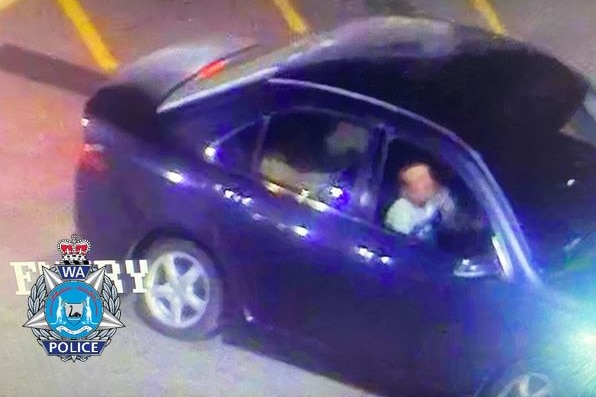 A still image of a blue car taken from CCTV footage, showing a man driving.