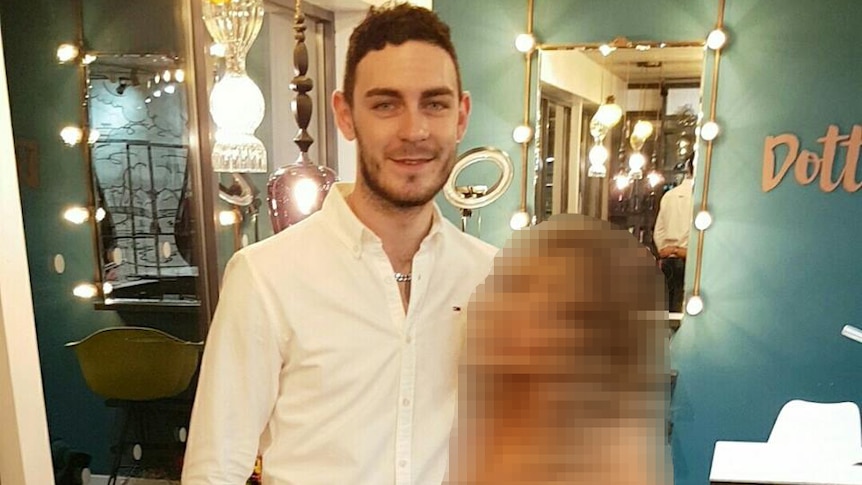 Mo Robinson smiles for a photo alongside a blurred-out woman