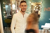 Mo Robinson smiles for a photo alongside a blurred-out woman