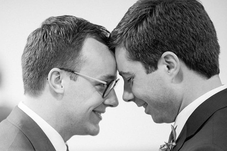 Two men in suits touch foreheads
