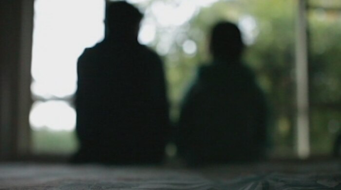 A silhouette of two people sitting.