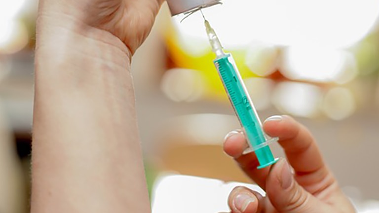Liquid medication being drawn into syringe.