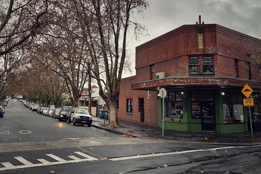 A tree-lined street in the suburb of Flemington with an old-fashioned shop on the corner.