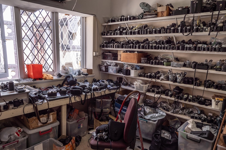 Shelves and a desk full of cameras.