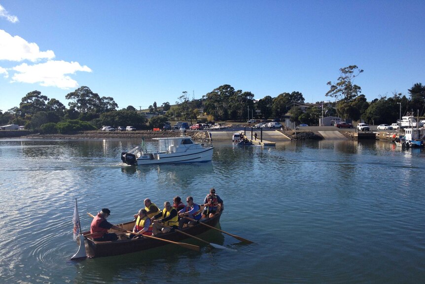 Tasmanian Infrastructure Minister, Rene Hidding being rowed across to a new boat ramp opened at Triabunna.