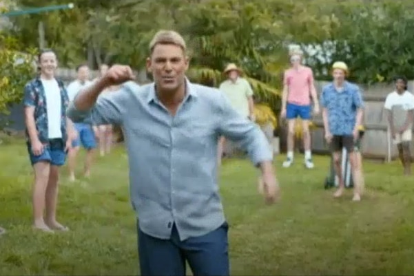 Shane Warne dress in casual jeans and shirt plays backyard cricket.