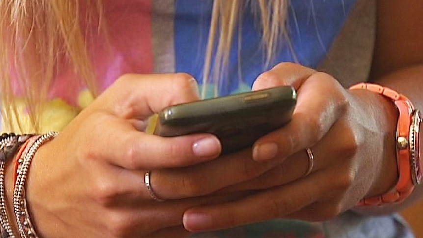 A girl's hands hold a mobile phone.