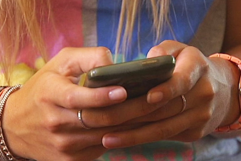 A girl's hands hold a mobile phone.