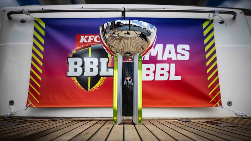 The Big Bash League trophy sits on the deck of a boat in front of a BBL sign in Hobart.