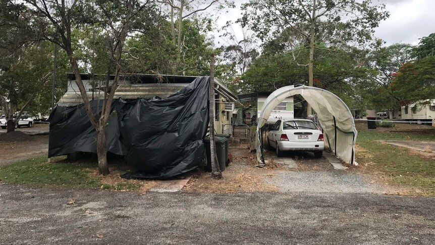 Police have put tarp over the back of a caravan to cover up the crime scene. 