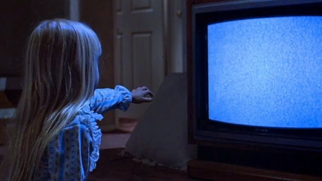 The young girl from Poltergeist puts her hand towards a static TV.