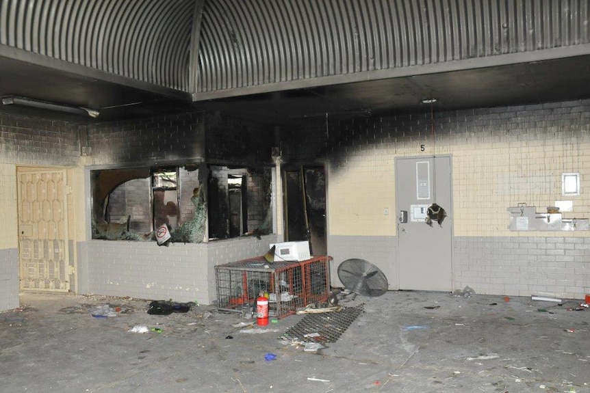 Fire damage at Greenough Regional Prison with walls scorched black, windows smashed and debris lying on the floor.