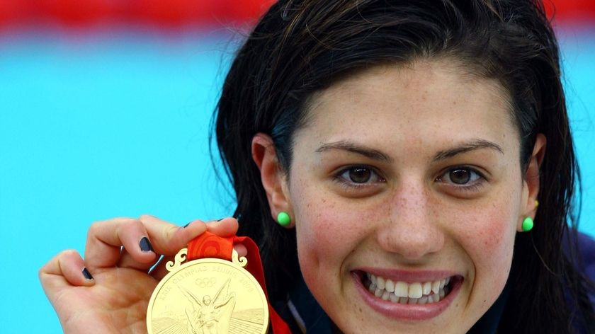 Stephanie Rice smiles while holding her gold medal after winning the women's 200m individual medley