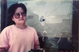 Liling Wang stands beside a bullet hole in a window in Beijing on June 8, 1989.