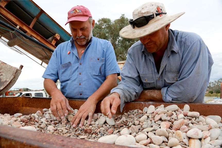 Miners sort through rocks and look for opals