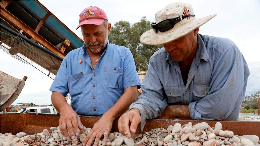 Miners sort through rocks and look for opals