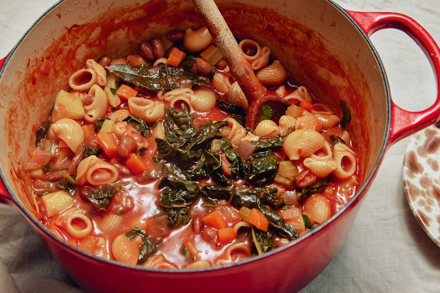 Dutch oven filled with minestrone, a hearty, vegetarian dinner for cooler months.