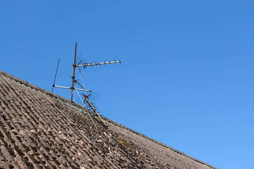 Broken antenna on top of a rooftop