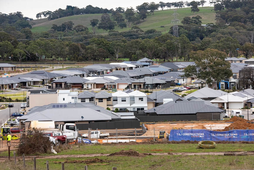 A cluster of new houses with hills in the background