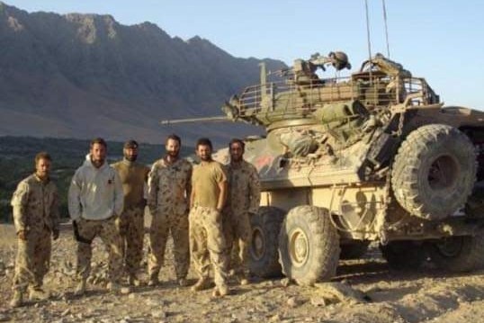Ben Wallace and five other servicemen stand next to a tank in Afghanistan.