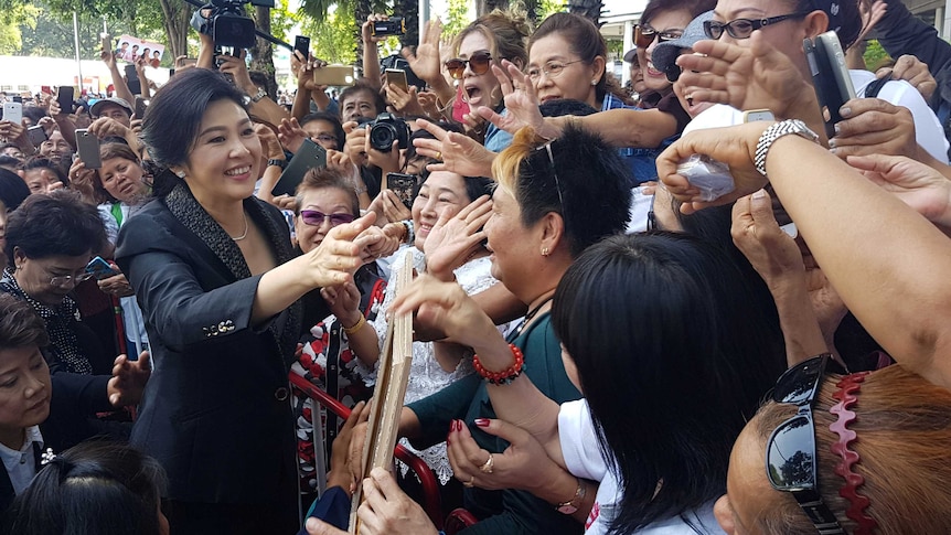 Ousted former Thai prime minister Yingluck Shinawatra greets supporters.