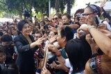 Ousted former Thai prime minister Yingluck Shinawatra greets supporters.