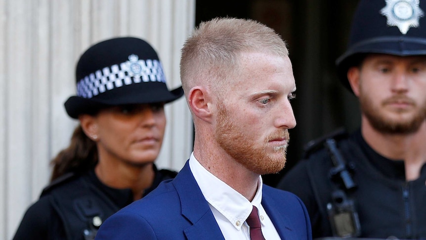 A ginger man leaves Bristol Crown Court with two police officers in the background.