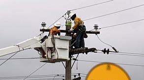 Workers of an electricity company repair power poles and cables damaged by cyclone Larry in Innisfai