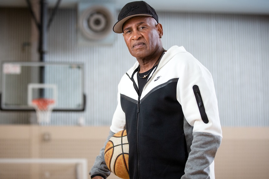 Cal Bruton holding a basketball on a court