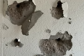 white wall with grey holes 