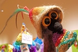 A crocheted emu head wearing a beanie.