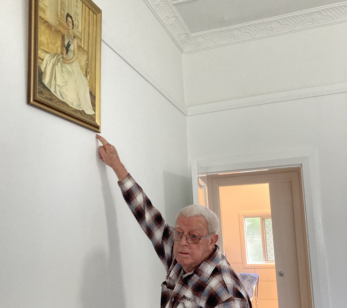 Man pointing to Queen's portrait