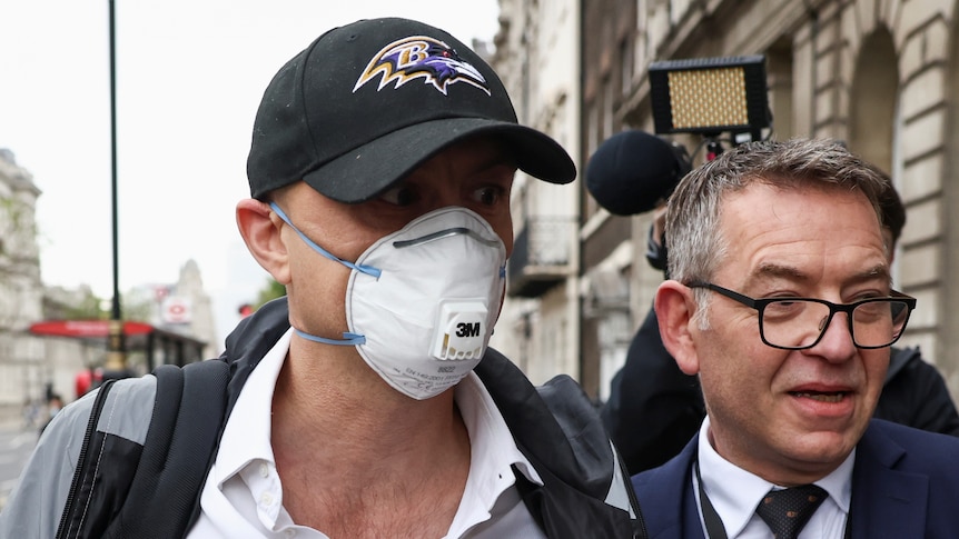 Boris Johnson's former adviser, Dominic Cummings, wears a face mask and Baltimore Ravens cap as he enters Portcullis House.
