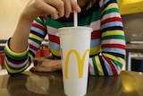 A young woman drinking a McDonald's thickshake