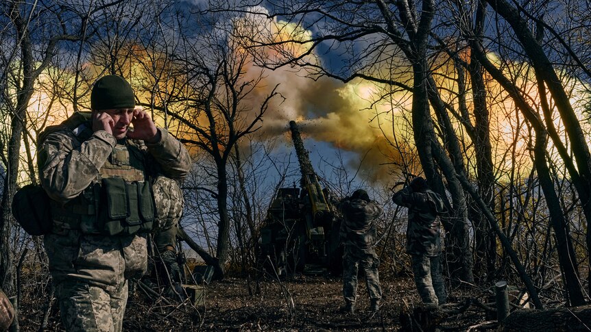 Yellow smoke fills the air as Ukrainian soldiers fire a self-propelled howitzer towards Russian positions.