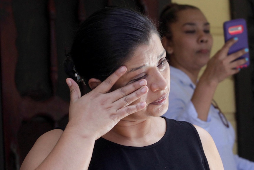 Karen Caballero wipes away a tear during a press conference at her house.