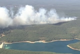 Smoke rising up from bushland seen from the air.