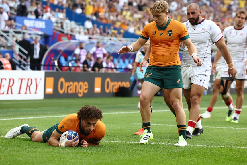 A Wallabies player lies on the ground after scoring a try against Georgia at the 2023 Rugby World Cup.