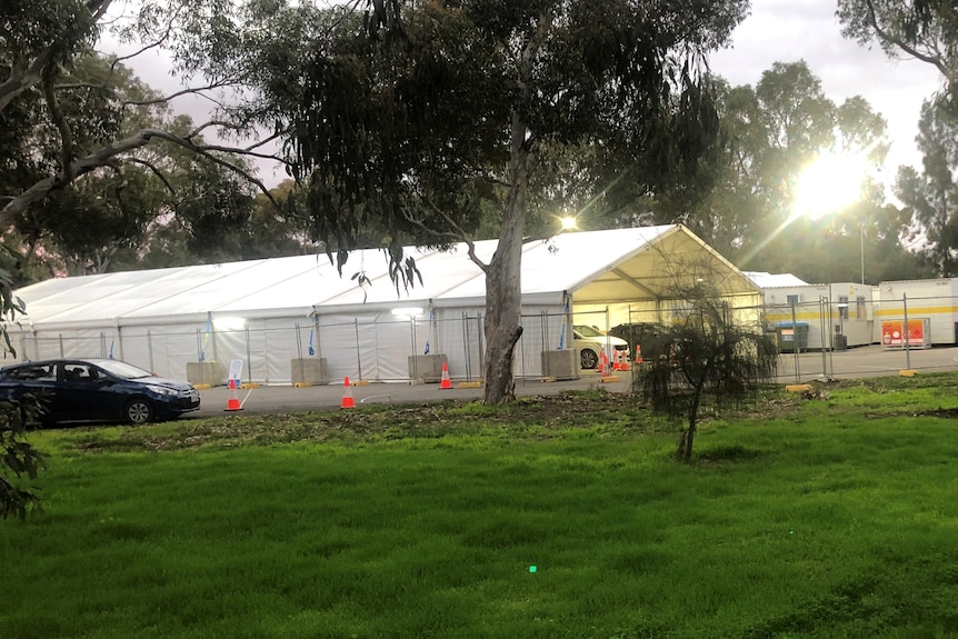 A marquee with cars going through it in a park