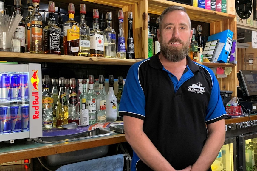 A man standing behind a bar.