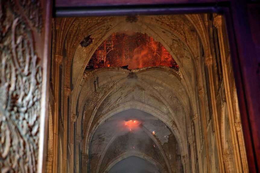 Flames and smoke billow out as stone vaults are seen saving cathedral from total destruction.