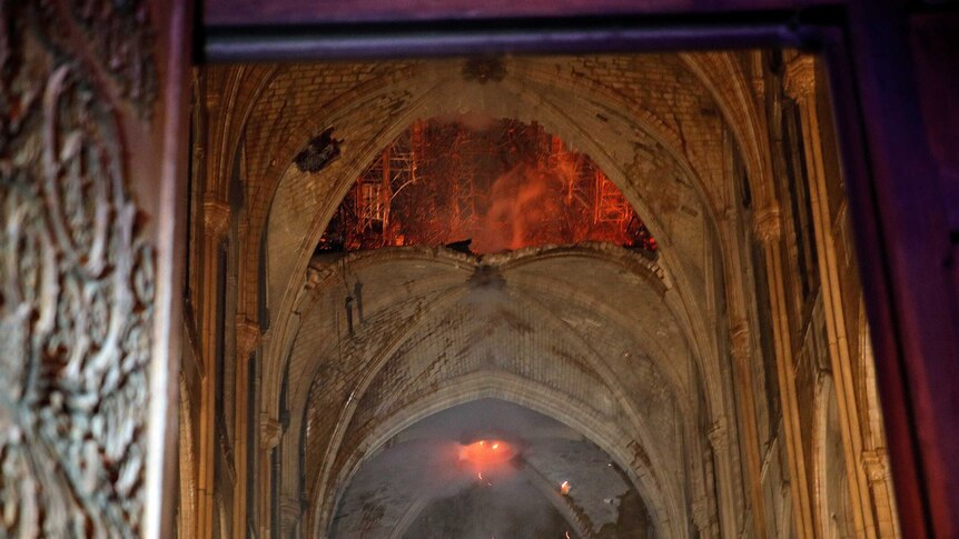 Flames and smoke billow out as stone vaults are seen saving cathedral from total destruction.