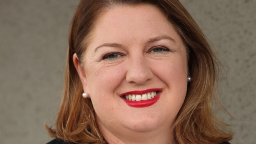 Headshot of woman with brown hair smiling at camera.