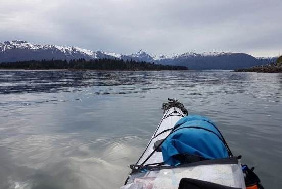 Kayak in the water with views of the snowy mountain range.