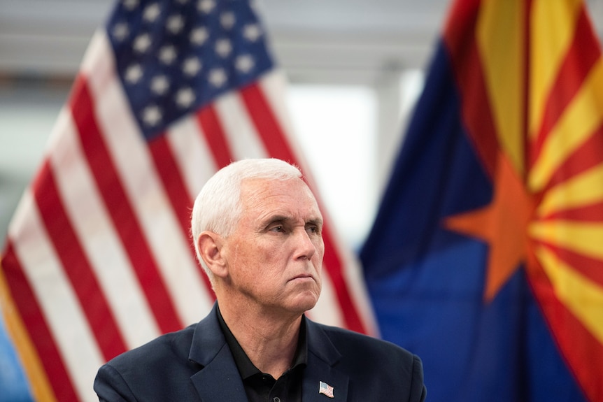 Mike Pence frowns in front of United States and Arizona flags