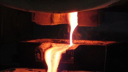 Hot metal being poured into a gold bar.
