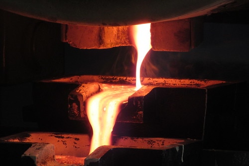 Hot metal being poured into a gold bar.