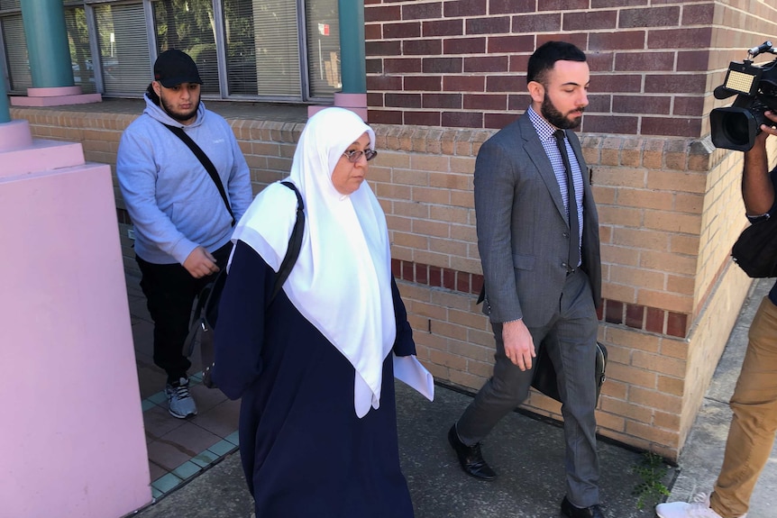 Maha Al-Shennag walks out of Burwood Local Court with her lawyer and a friend by her side.